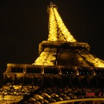 L atour Eiffel illuminée en jaune de nuit.